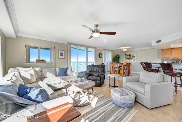 tiled living room featuring a water view, ceiling fan, and ornamental molding