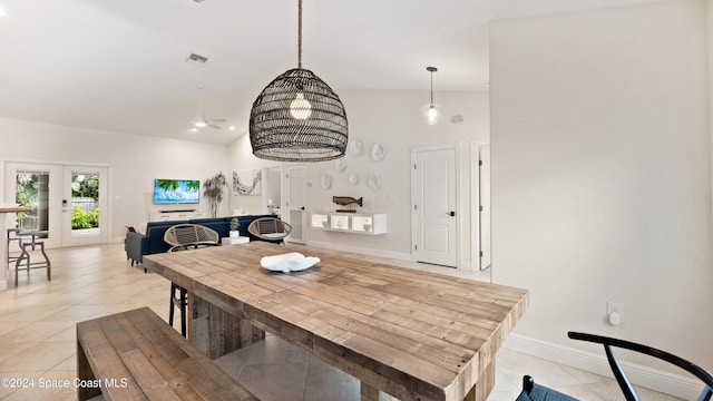 tiled dining area featuring high vaulted ceiling