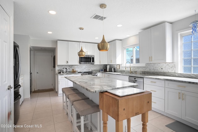 kitchen featuring white cabinets, a center island, and stainless steel appliances