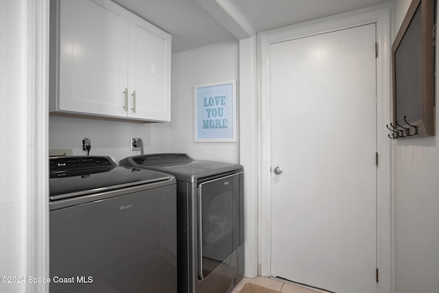 washroom with washer and dryer, light tile patterned floors, and cabinets