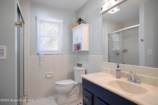 bathroom featuring vanity, toilet, walk in shower, and tile walls