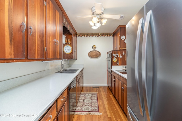 kitchen featuring sink, appliances with stainless steel finishes, light hardwood / wood-style floors, and ceiling fan