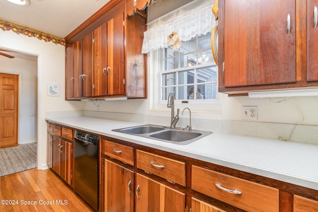 kitchen with black dishwasher, sink, light wood-type flooring, and ceiling fan