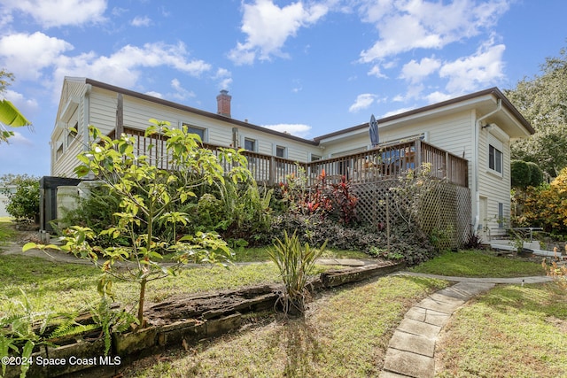 back of property with a yard and a deck