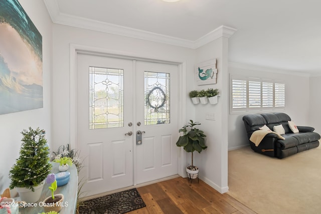 foyer entrance with ornamental molding and wood-type flooring