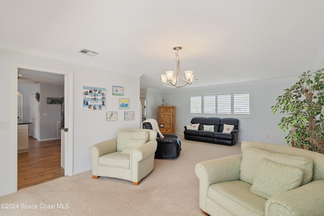 living room with an inviting chandelier, hardwood / wood-style floors, and crown molding