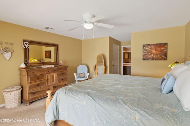 carpeted bedroom featuring ensuite bath and ceiling fan