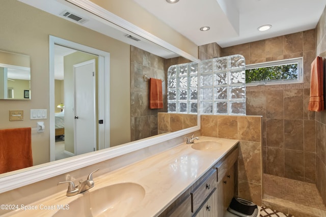 bathroom with vanity and a tile shower