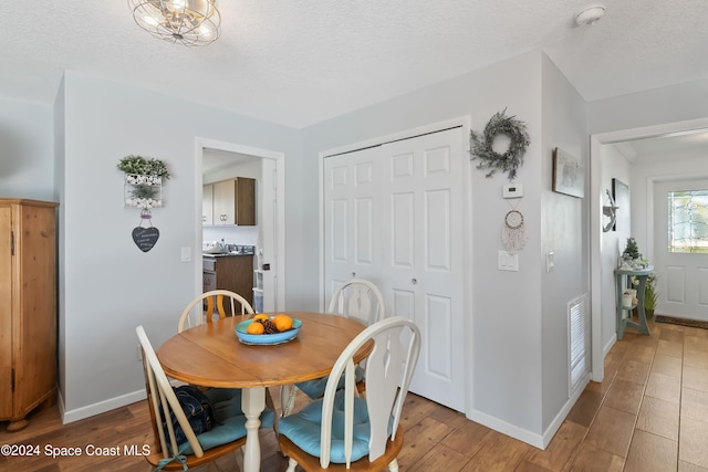 dining area featuring a textured ceiling and hardwood / wood-style flooring