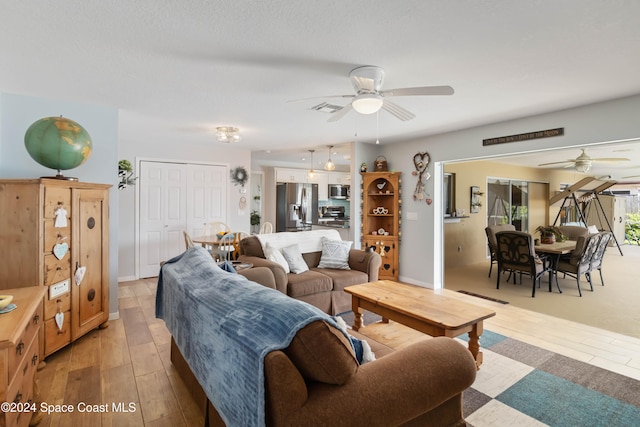 living room with light wood-type flooring and ceiling fan