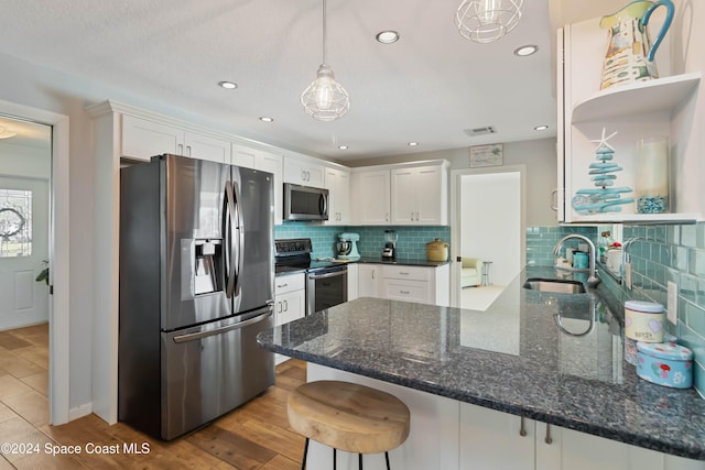 kitchen featuring hardwood / wood-style floors, white cabinets, stainless steel appliances, and sink