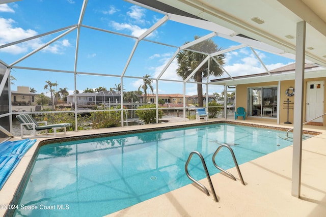 view of swimming pool with a patio area and a lanai