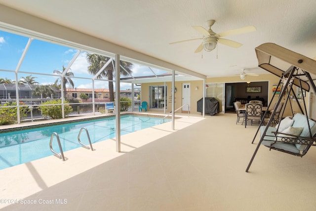 view of pool with a lanai, a patio area, and ceiling fan