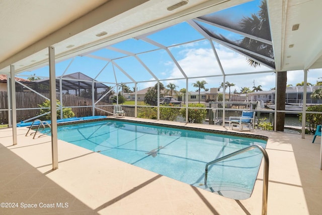 view of swimming pool featuring a patio area and a lanai