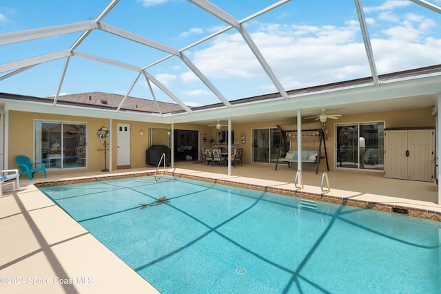 view of pool with ceiling fan, a lanai, and a patio area