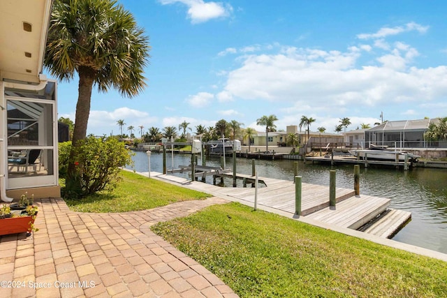 dock area featuring a lanai, a lawn, and a water view