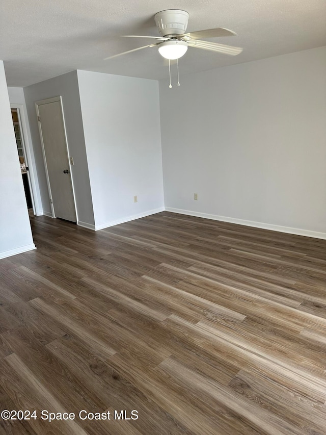 empty room with ceiling fan, a textured ceiling, and dark hardwood / wood-style flooring