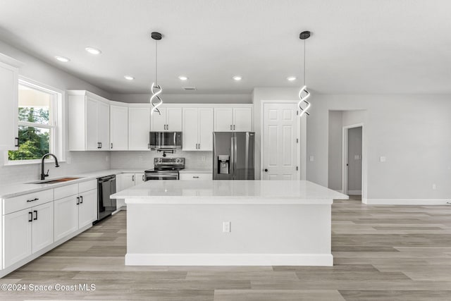 kitchen featuring a center island, stainless steel appliances, white cabinetry, and sink