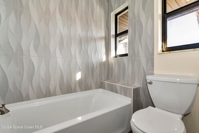 bathroom featuring tile walls, a bathing tub, and toilet