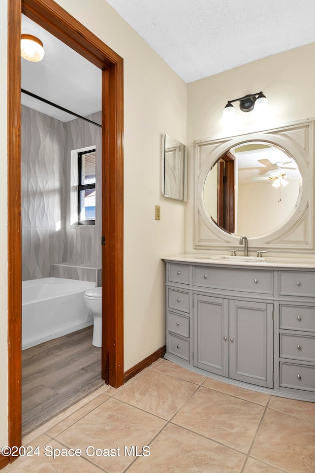 full bathroom with tile patterned flooring, a textured ceiling, shower / bathing tub combination, vanity, and ceiling fan