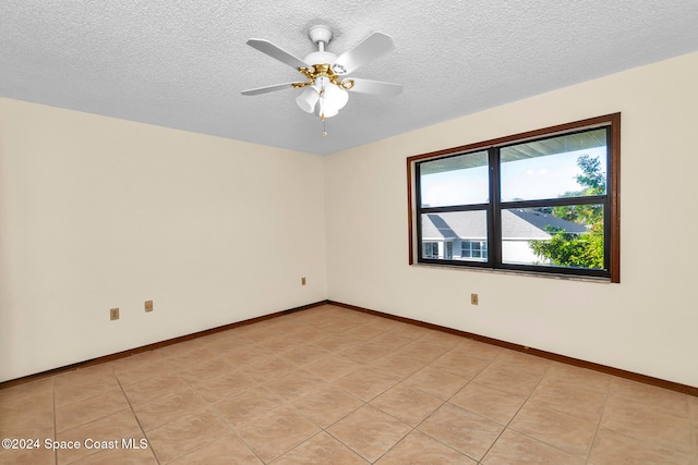 unfurnished room featuring a textured ceiling, light tile patterned floors, and ceiling fan