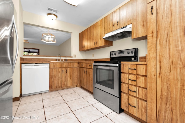 kitchen with stainless steel appliances, hanging light fixtures, sink, and light tile patterned flooring