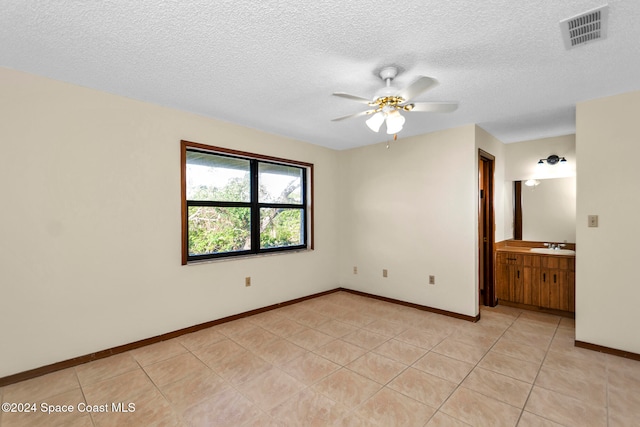 unfurnished room featuring light tile patterned flooring, sink, a textured ceiling, and ceiling fan