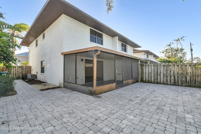 back of property featuring cooling unit, a patio, and a sunroom