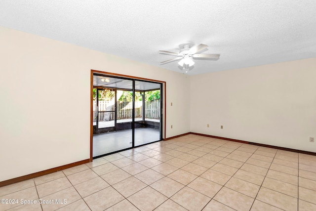 tiled spare room featuring a textured ceiling and ceiling fan