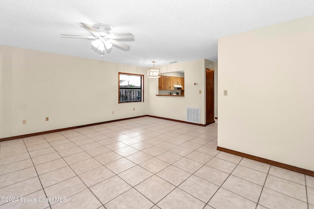 tiled spare room with a textured ceiling and ceiling fan