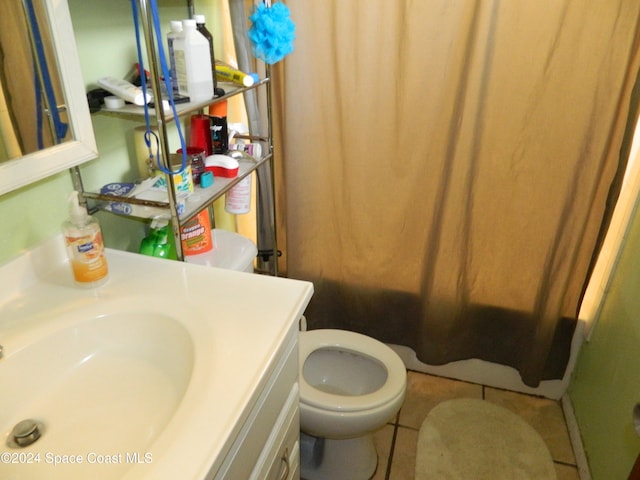 bathroom featuring tile patterned flooring, vanity, curtained shower, and toilet