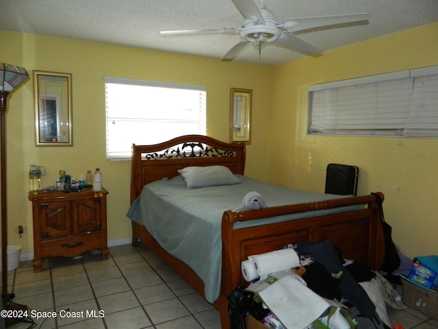 tiled bedroom with a textured ceiling and ceiling fan