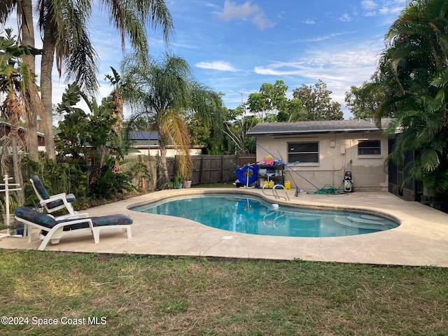 view of swimming pool with a patio area and a lawn