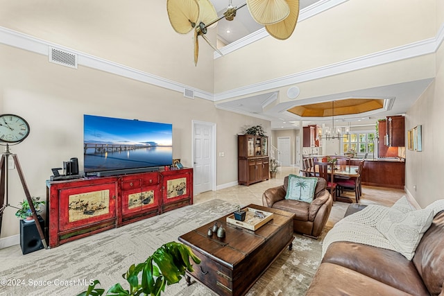 tiled living room featuring ornamental molding, a high ceiling, and ceiling fan with notable chandelier