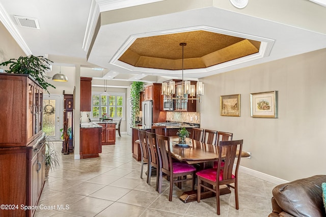 dining room with a notable chandelier, ornamental molding, light tile patterned flooring, and a raised ceiling