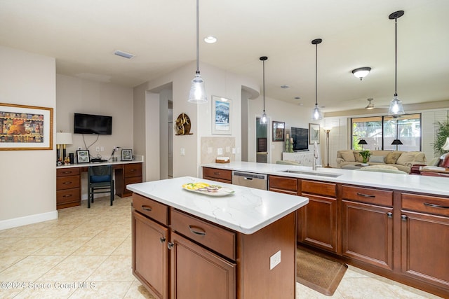 kitchen featuring stainless steel dishwasher, open floor plan, decorative light fixtures, and a sink