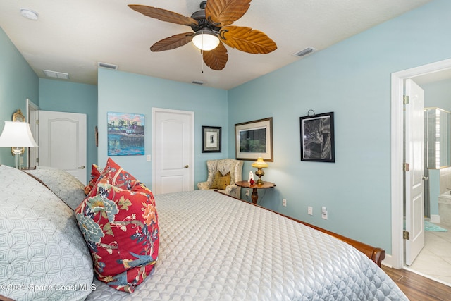 bedroom featuring connected bathroom, hardwood / wood-style flooring, and ceiling fan