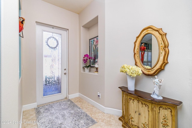 entryway featuring light tile patterned floors and baseboards