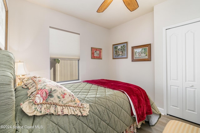 bedroom with ceiling fan, wood finished floors, and a closet