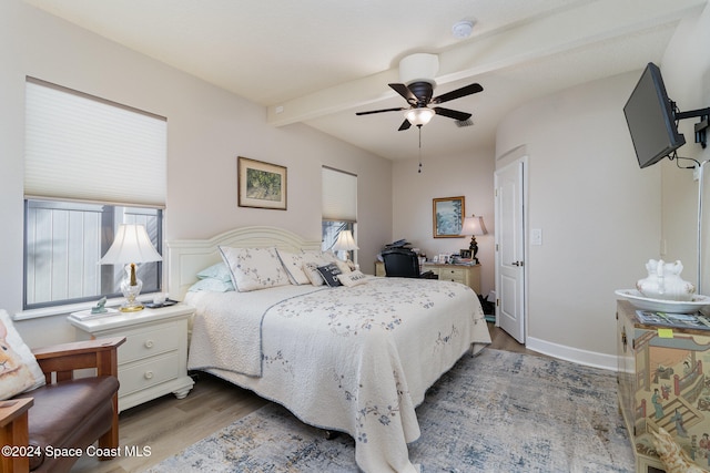 bedroom featuring beam ceiling, hardwood / wood-style floors, and ceiling fan