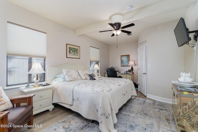 bedroom featuring wainscoting, ceiling fan, wood finished floors, and beam ceiling