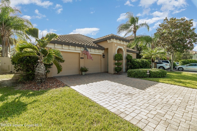 mediterranean / spanish-style house featuring a front lawn and a garage