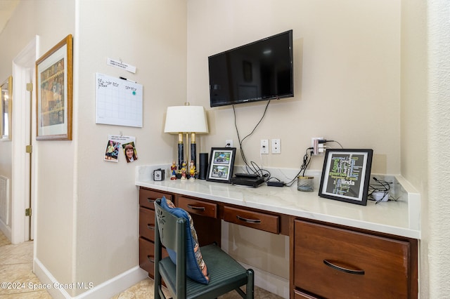 office with built in desk and light tile patterned flooring