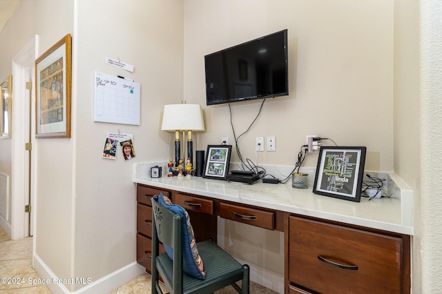 office space featuring baseboards and built in desk