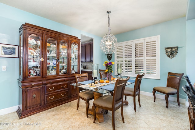 dining area with plenty of natural light, light tile patterned floors, and a chandelier