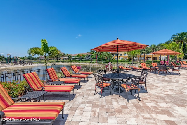 view of patio with a water view and an outdoor fire pit