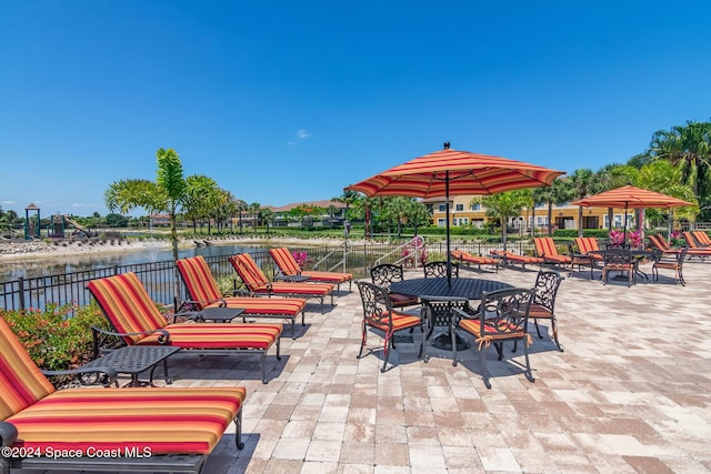 view of patio featuring a water view and fence