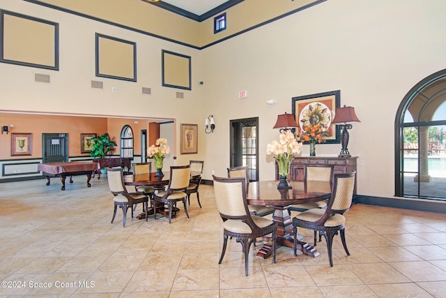 dining space featuring crown molding, pool table, visible vents, and a towering ceiling