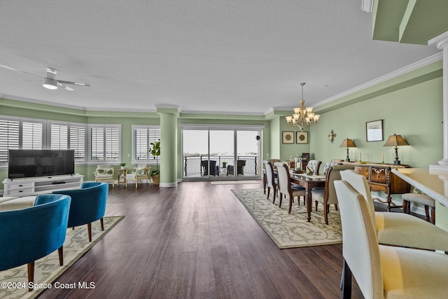 interior space with ceiling fan with notable chandelier, a textured ceiling, decorative columns, dark wood-type flooring, and ornamental molding