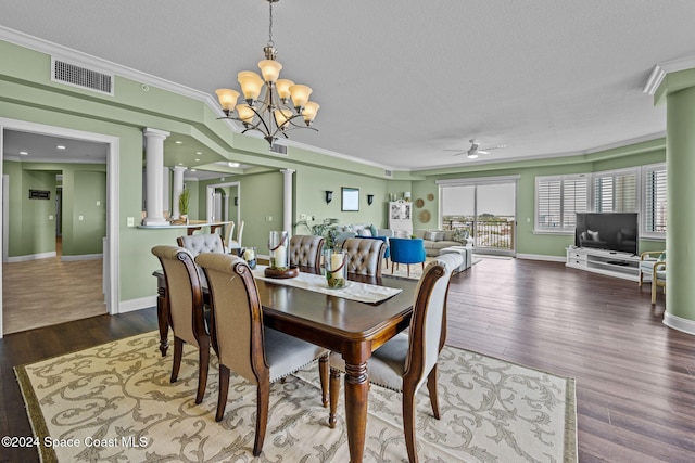 dining area featuring ornate columns, hardwood / wood-style flooring, ornamental molding, a textured ceiling, and ceiling fan with notable chandelier